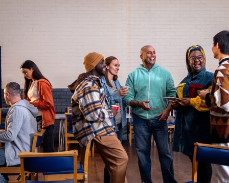 A group of colleagues talking in a break room at work