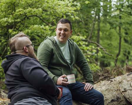Men sitting on tree talking