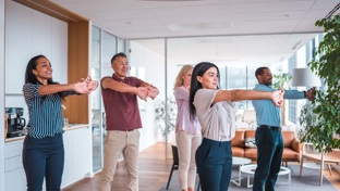 Colleagues doing yoga in an office