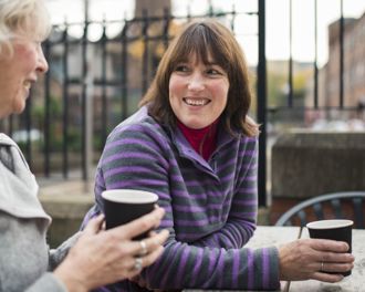 Two woman enjoying a hot beverage on a cold day.jpg