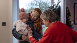 Family being greeted as they enter the front door