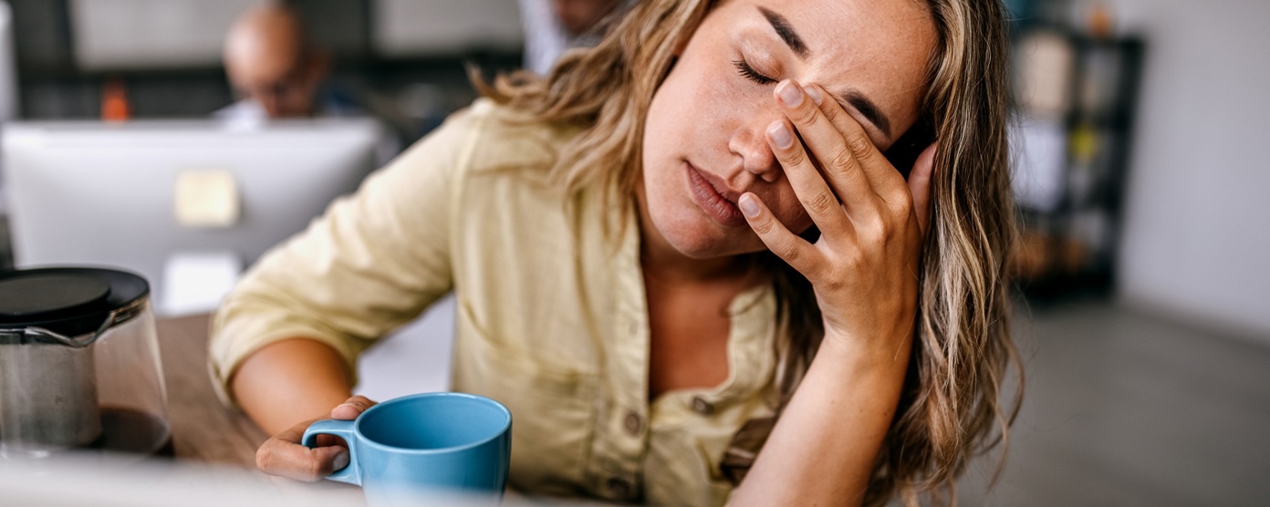 Woman at desk with her hand to her face