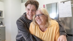 Man cuddling woman