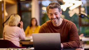 Man smiling using a laptop