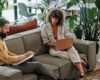 Women sat on sofa with laptop