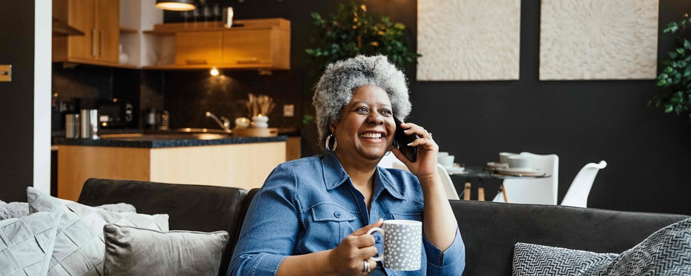 Lady smiling on the phone in her living room